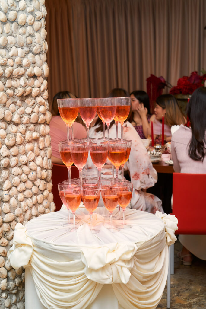 A rose champagne tower built on a draped table at a private party at TUBA Bangkok