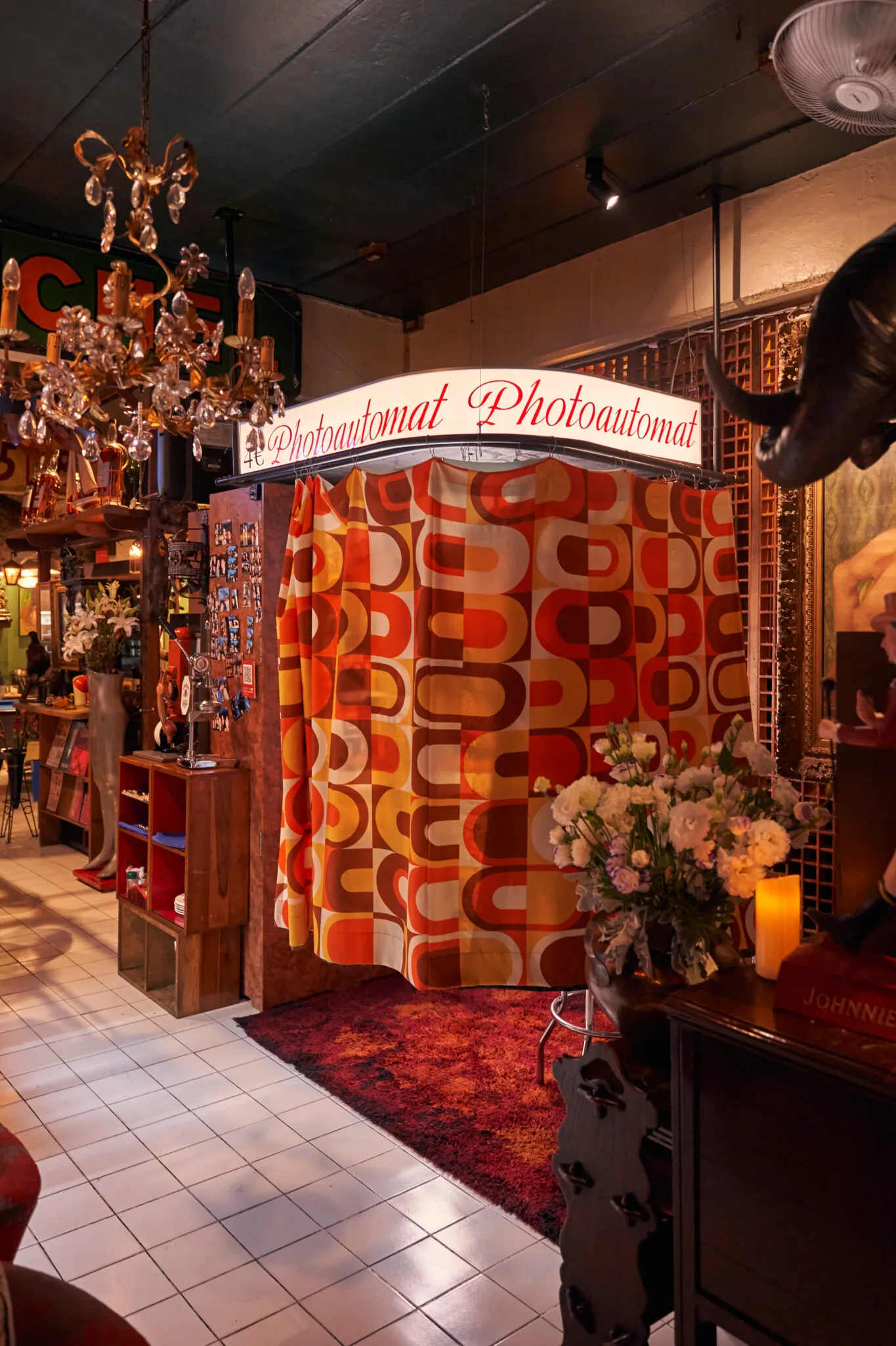 Retro Photoautomat photo booth with a patterned curtain and fresh flowers at TUBA Bangkok